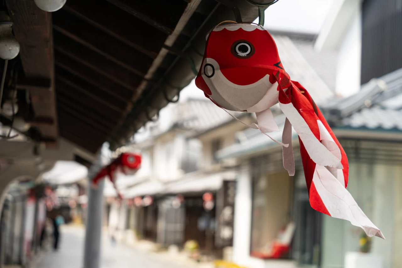 白壁の町並みの軒先につるされた金魚ちょうちん