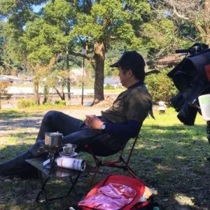 初夏の晴れた午後に名水で淹れたコーヒーを楽しむ、ソロツーリング中の筆者（男性、バイク歴40年）