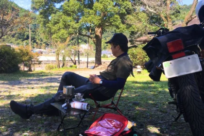 初夏の晴れた午後に名水で淹れたコーヒーを楽しむ、ソロツーリング中の筆者（男性、バイク歴40年）