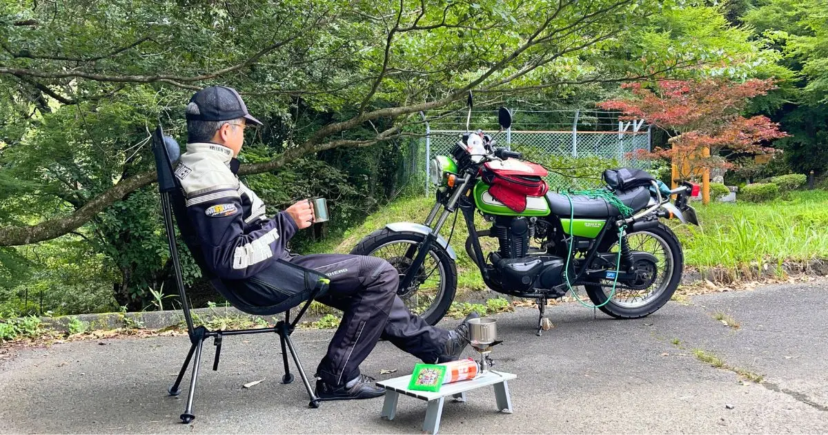 熊本県産山村の山吹水源駐車場で、名水コーヒーを楽しむソロツーリング中の筆者（男性、バイク歴40年超）